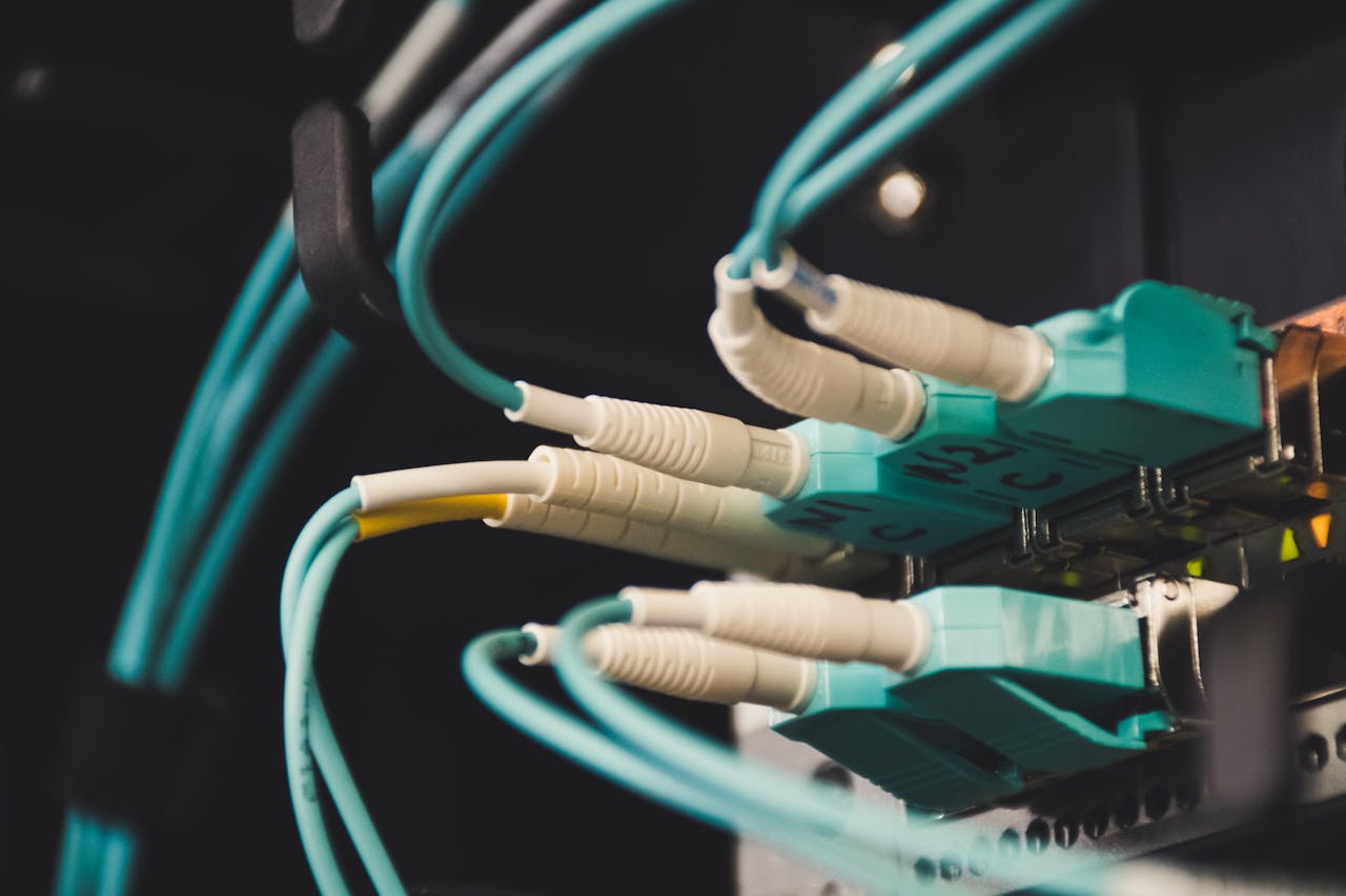 who-we-are Detailed view of fiber optic cables and ports in a server room, showcasing connectivity.